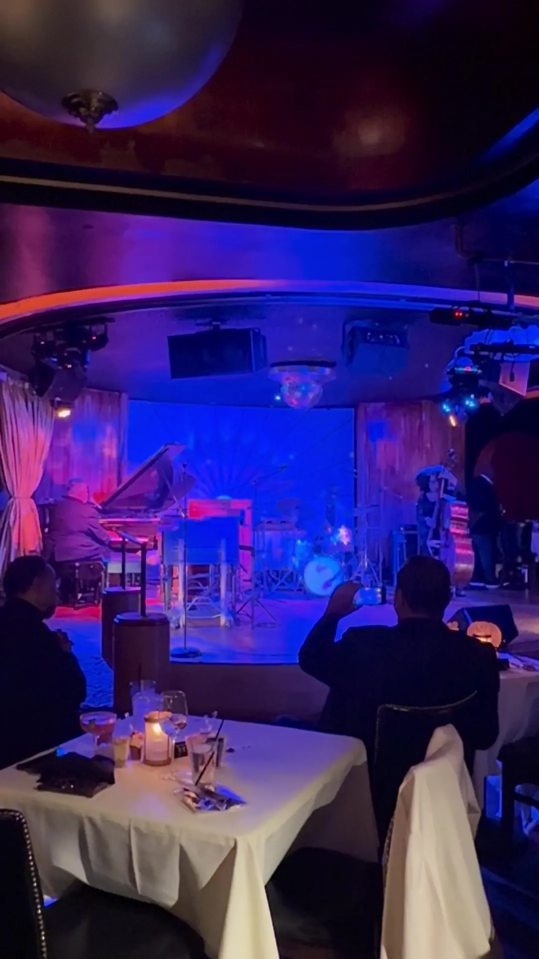 White-linen tables with candles face the stage at Cliff Bell's jazz club