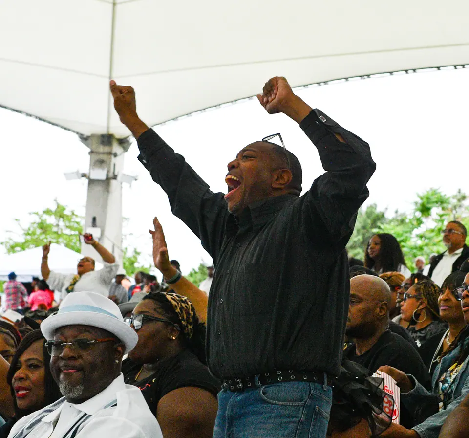 A guest with both arms raised mid-show