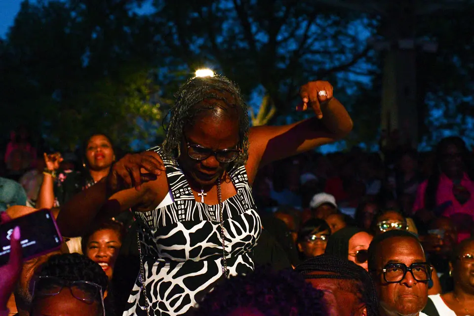 A guest dances in the aisle, surrounded by a smiling crowd at dusk
