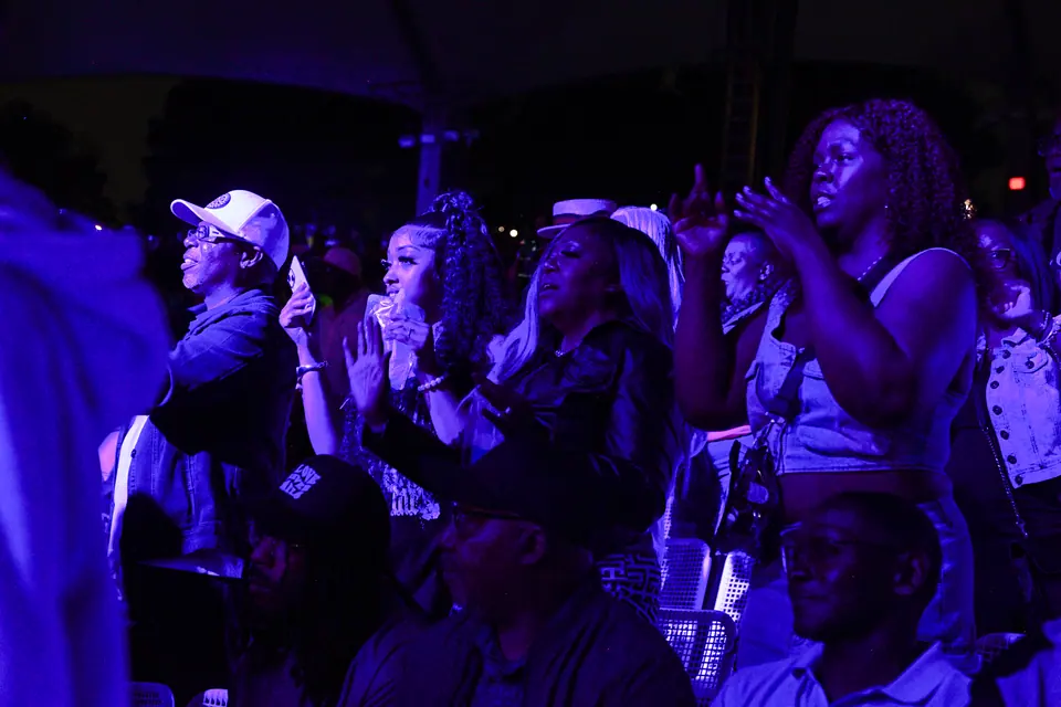 Fans singing along under blue light
